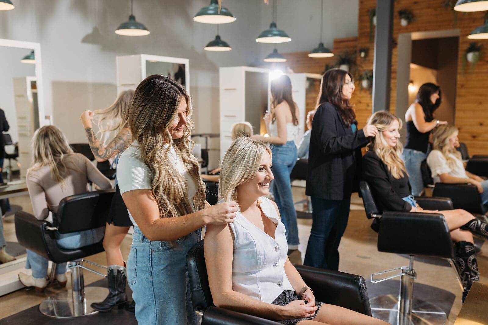 A stylist styling a client's hair at a station on the bex+Co.® salon floor